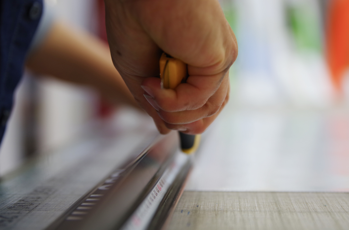 Folie für Beschriftung eines Werbeschildes zuschneiden