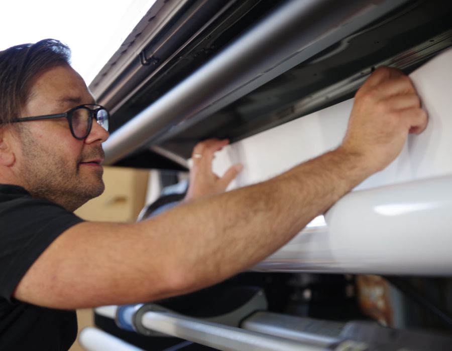 Harry legt Folie in den Folienplotter für die Beschriftung ein